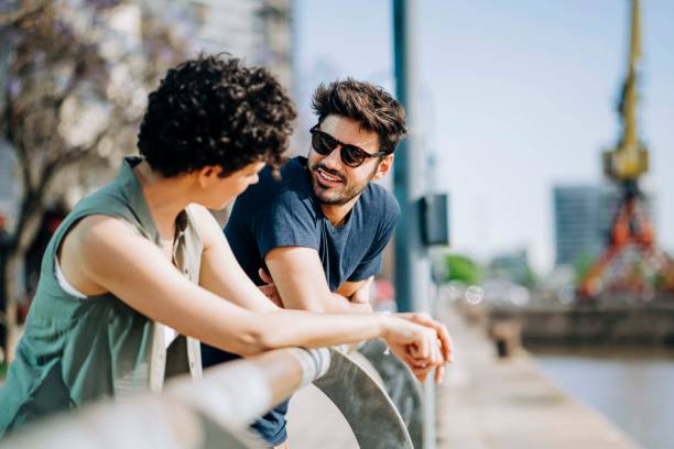istock Couple talking while leaning on railing in city 1192896065
