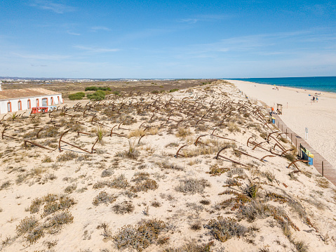 Anchor graveyard on snady dunes of Barril beach, Algarve, Portugal
