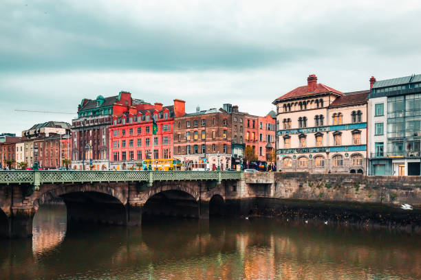 Dublin, Ireland - November 8, 2018: Old city with colorful brick buildings of vintage cafe, pubs, Sunlight Chambers on Liffey's riverside. Tourists on Grattan bridge and Wellington quay. Temple Bar