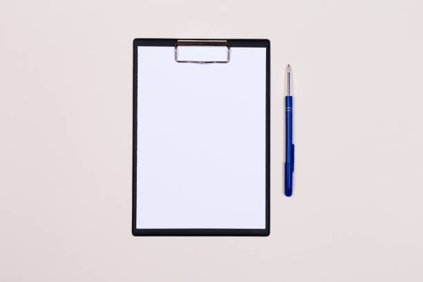 istock Clipboard with white sheet and pen on a colored background. View from above. space for text 1192897500