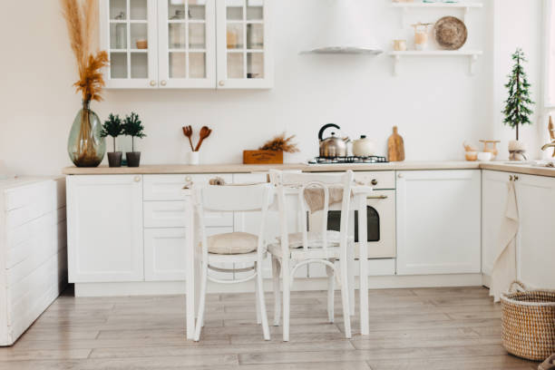 istock Modern new bright kitchen interior with white furniture and a dining table. 1192897758