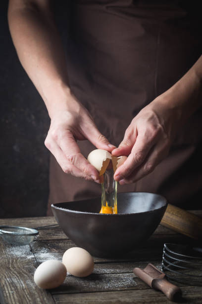 손이 달걀을 부수고 있다 - rolling dough pastry apron 뉴스 사진 이미지