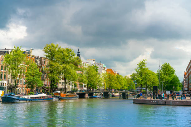 Amsterdam, June 13th, 2019 - Tourist visiting the Jewish resistans monument at the corner of the River Amstel and the Zwanenburgwal in the old part of Amsterdam