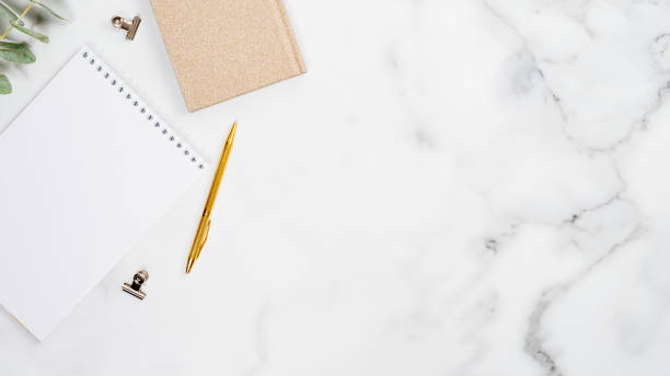 istock Home office desk table with blank paper notepad and supplies on marble background. Flat lay, top view. Modern blogger desktop concept. 1192900005