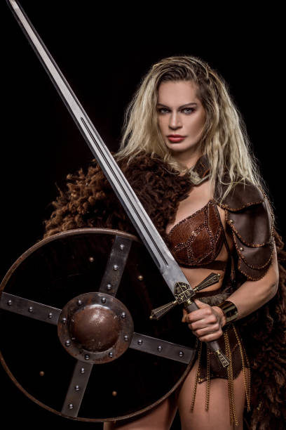 istock Sword wielding viking warrior young blond female in studio shot 1192902979