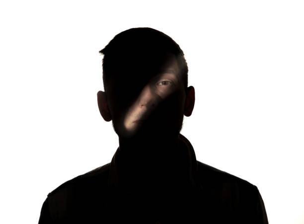 istock Dramatic portrait of a man in the dark on white studio background. 1192903743