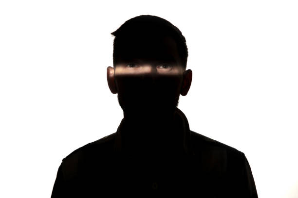 istock Dramatic portrait of a man in the dark on white studio background. 1192903758