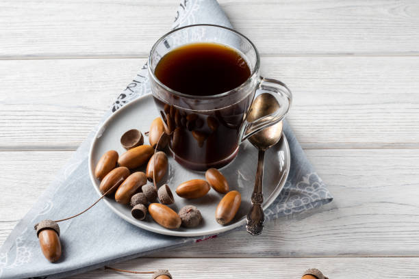 Acorn coffee is a tonic with a coffee flavor, rich color and pleasant aroma. On a white wooden background stock photo