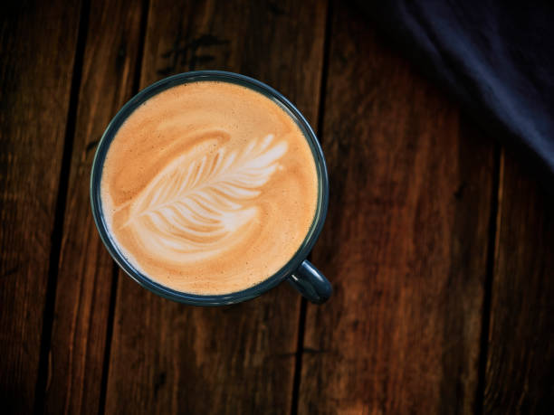 Flat White Coffee from above on a dark aged wood table.