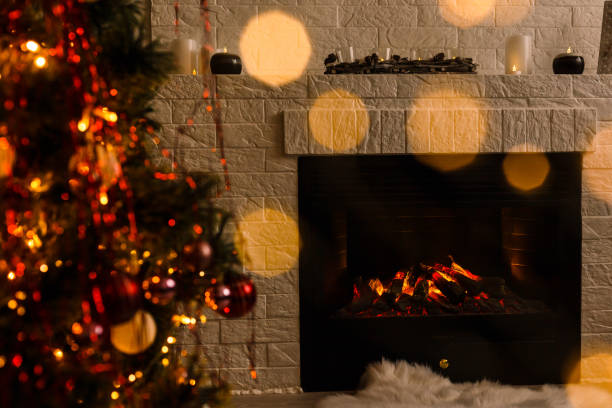 istock Christmas tree near fireplace in room 1192905573