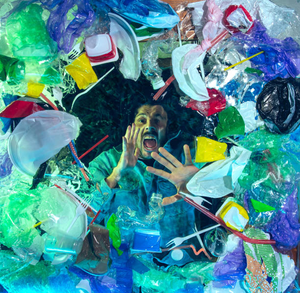istock Man drowning in ocean water under plastic recipients pile, environment concept 1192906807