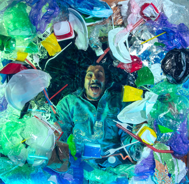 istock Man drowning in ocean water under plastic recipients pile, environment concept 1192906816