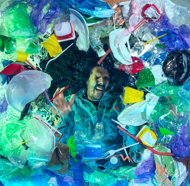 istock Man drowning in ocean water under plastic recipients pile, environment concept 1192906817
