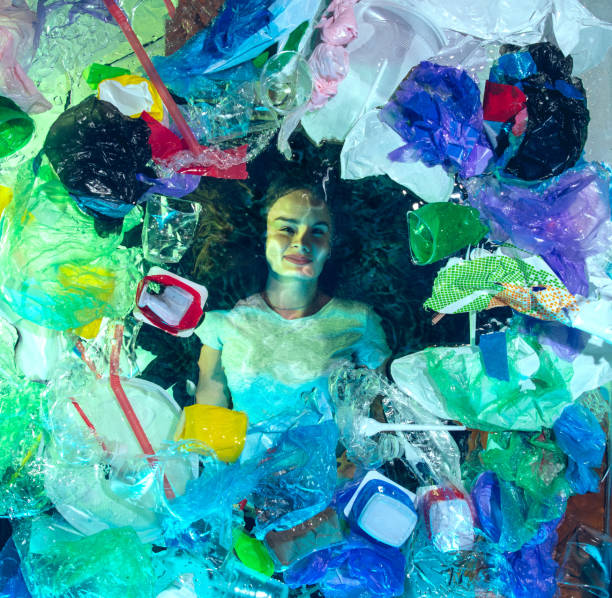 istock Woman drowning in ocean water under plastic recipients pile, environment concept 1192906821