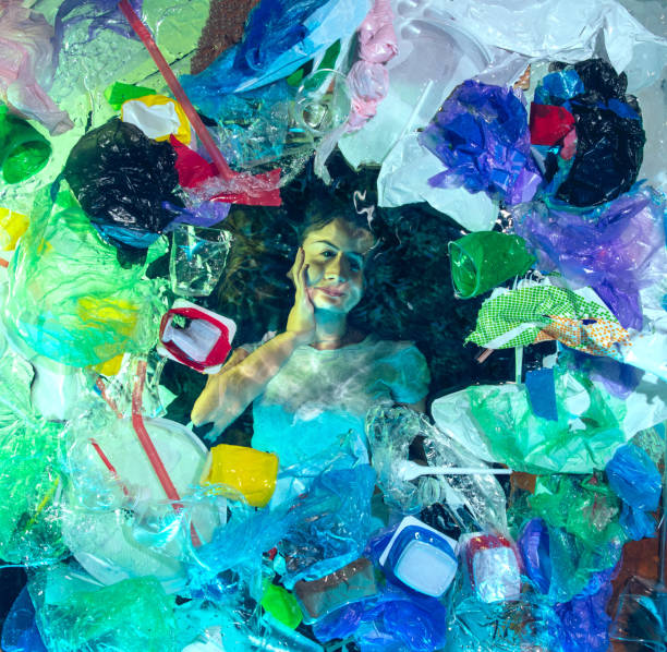 istock Woman drowning in ocean water under plastic recipients pile, environment concept 1192906826