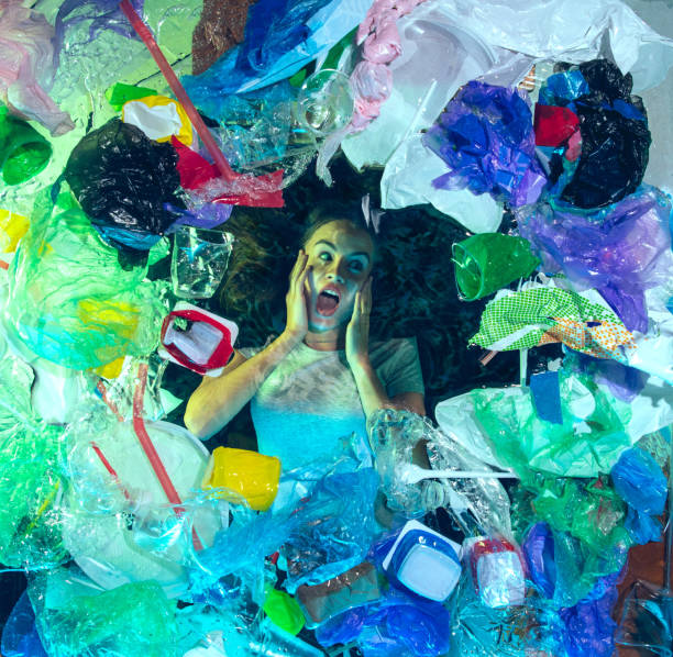 istock Woman drowning in ocean water under plastic recipients pile, environment concept 1192906827