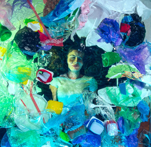 istock Woman drowning in ocean water under plastic recipients pile, environment concept 1192906830