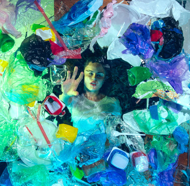 istock Woman drowning in ocean water under plastic recipients pile, environment concept 1192906838