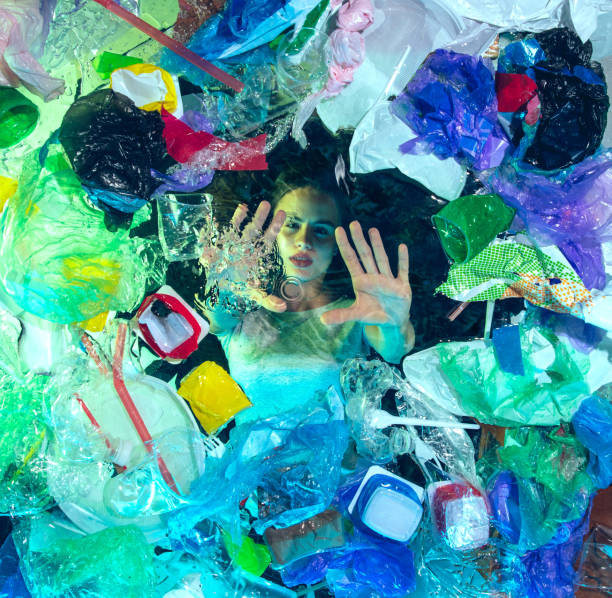 istock Woman drowning in ocean water under plastic recipients pile, environment concept 1192906839