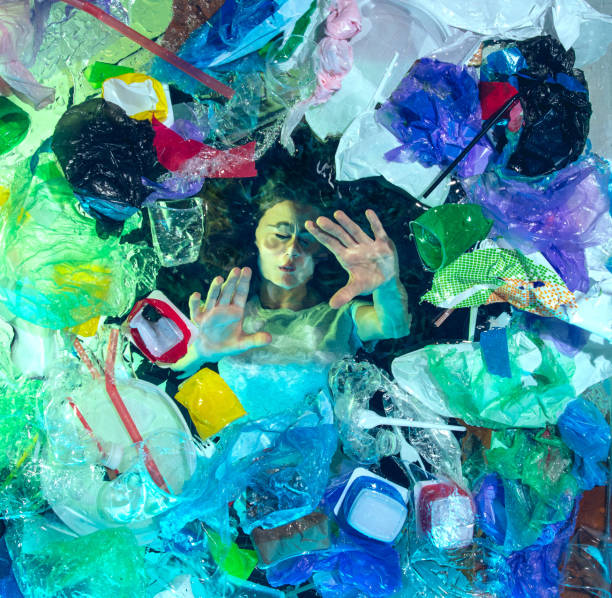 istock Woman drowning in ocean water under plastic recipients pile, environment concept 1192906844