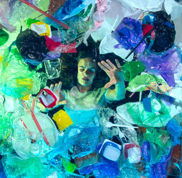 istock Woman drowning in ocean water under plastic recipients pile, environment concept 1192906846