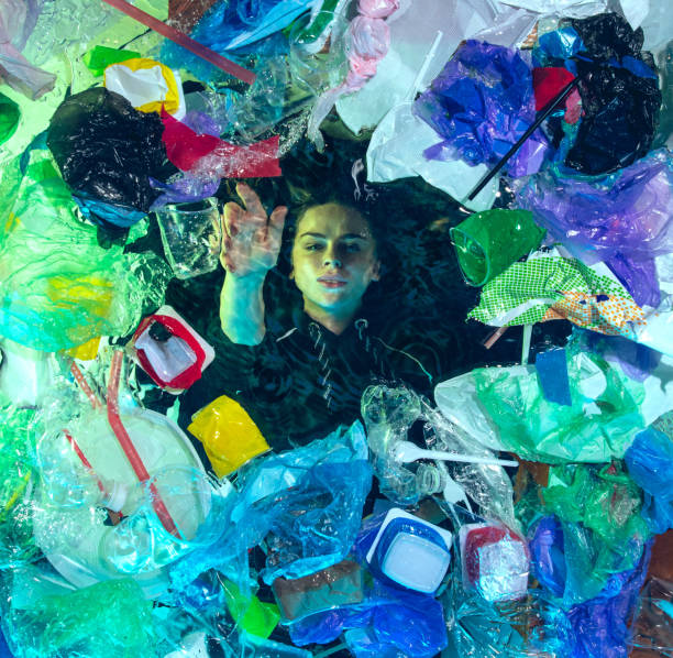 istock Woman drowning in ocean water under plastic recipients pile, environment concept 1192906856