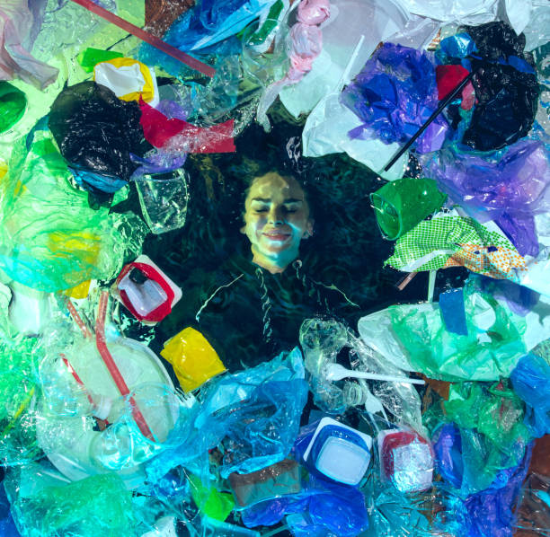 istock Woman drowning in ocean water under plastic recipients pile, environment concept 1192906858