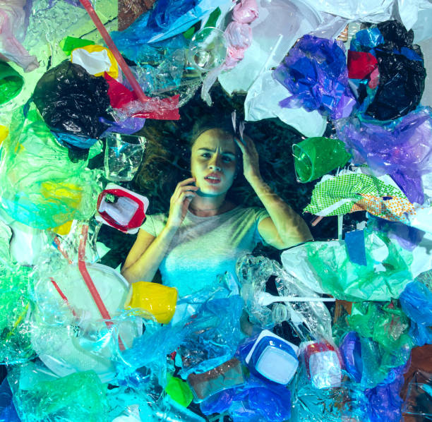 istock Woman drowning in ocean water under plastic recipients pile, environment concept 1192906862
