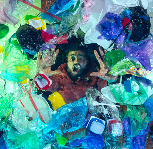 istock Man drowning in ocean water under plastic recipients pile, environment concept 1192906884