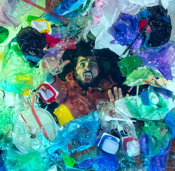 istock Man drowning in ocean water under plastic recipients pile, environment concept 1192906886