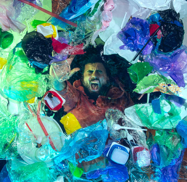 istock Man drowning in ocean water under plastic recipients pile, environment concept 1192906889