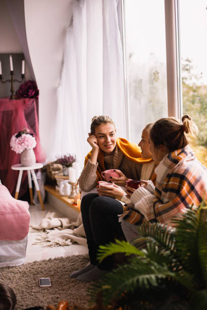 istock Side view of young friends bonding by the window 1192906945