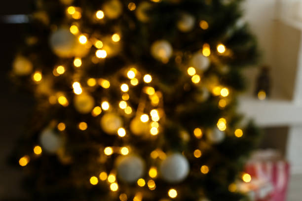 istock blur light celebration on christmas tree with white wall background 1192907502