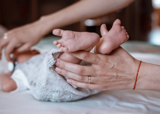 istock Newborn Baby's feet on female hands closeup. 1192907541