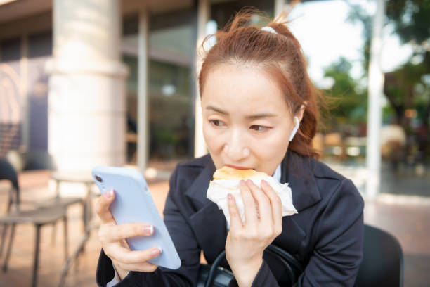 istock Busy young woman using smartphone while working on digital tablet in an outdoor cafe 1192908617