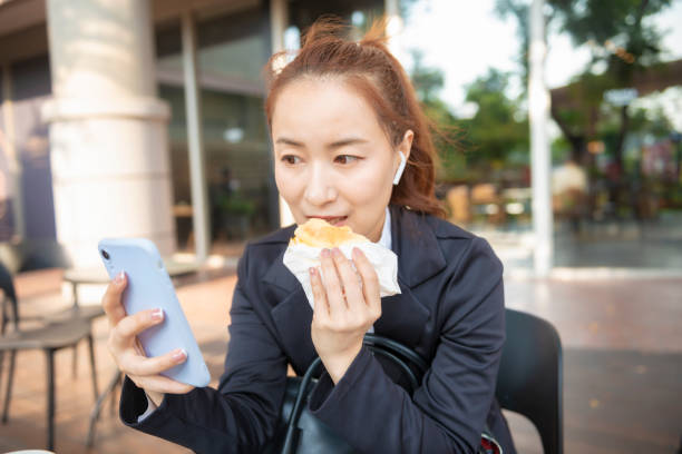 istock Busy young woman using smartphone while working on digital tablet in an outdoor cafe 1192908679