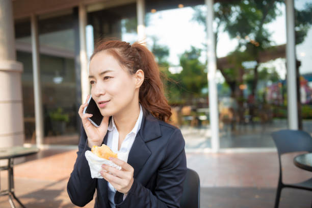 istock Busy young woman using smartphone while working on digital tablet in an outdoor cafe 1192908691