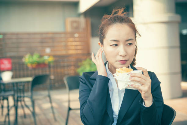 istock Busy young woman using smartphone while working on digital tablet in an outdoor cafe 1192908812