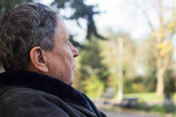 istock Senior man sitting on bench in the park 1192909165