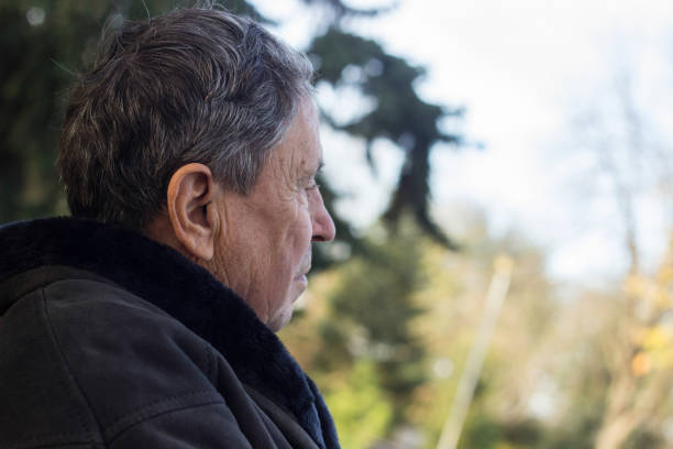 istock Senior man sitting on bench in the park 1192909220