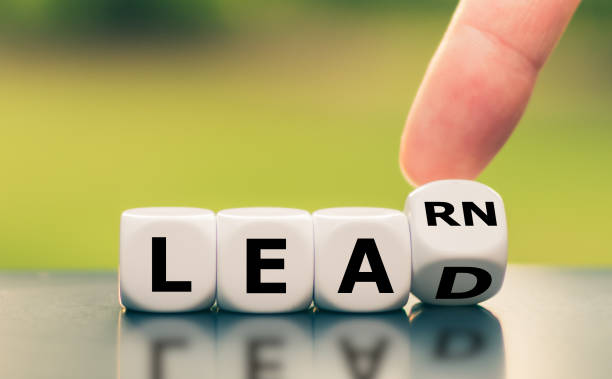 istock Learn and Lead. Hand turns a dice and changes the word 
