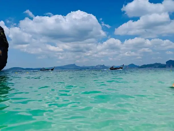 Aonang, Krabi / Thailand - February 11, 2019: Aonang Beach, the beautiful and famous place in Thailand. Blue sky cloudy, mountain and green sea with long tail boats, good for the vacation season.