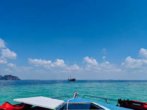 Aonang, Krabi / Thailand - February 11, 2019: Aonang Beach, the beautiful and famous place in Thailand, blue sky cloudy and green sea with the front of speed boat, good for the vacation season.