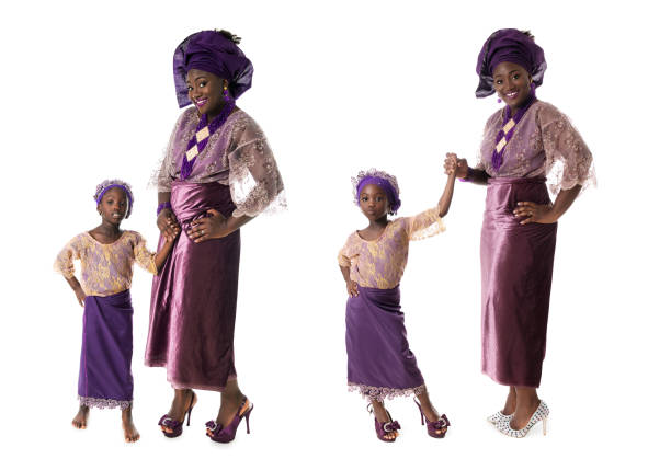 concept d'enfance et de famille - femme africaine et belle petite fille dans le costume pourpre traditionnel d'isolement - nigeria african culture dress smiling photos et images de collection