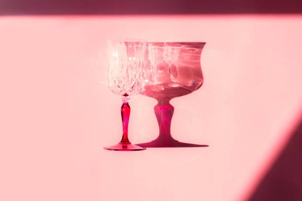 Stemmed glass and shadow. Pink monochrome minimal color flat lay