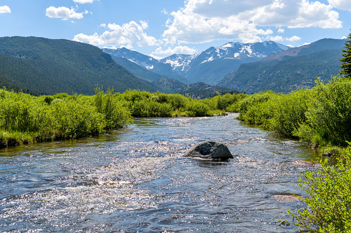 A Spring view of broad and rushing Big Thompson River at Moraine Park in Rocky Mountain National Park, Colorado, USA.