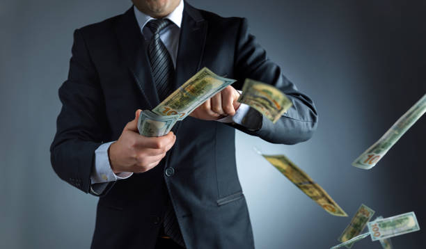 Businessman throwing dollar banknotes in air Businessman throwing dollar banknotes in air tossing stock pictures, royalty-free photos & images