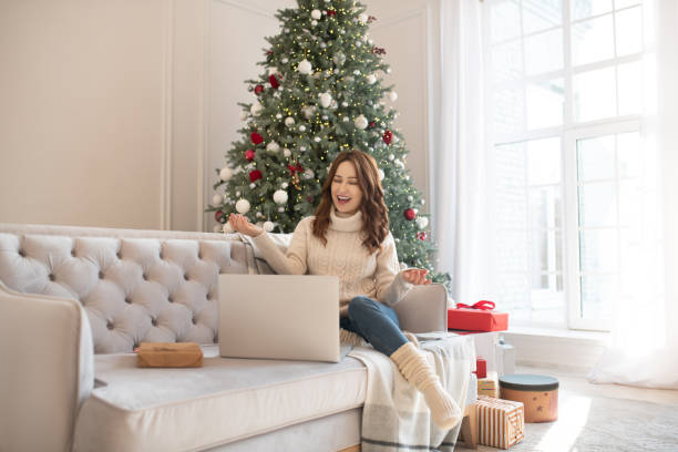 istock Dark-haired woman near christmas tree having a video call 1192914093