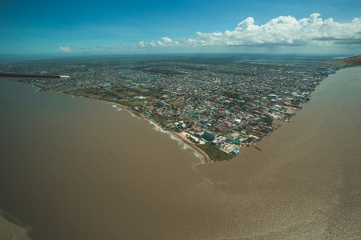 View from the plane over the capital city of Guyana, Georgetown, and the Demerara River and the Atlantic Ocean.