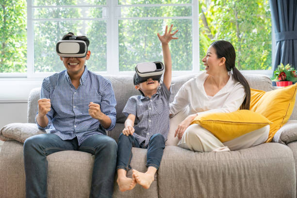 Father, mother and sons playing video games. stock photo